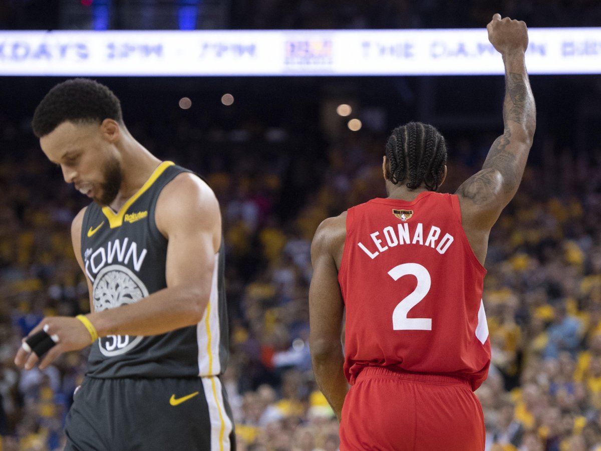 2HRJW74 Toronto Raptors' Kawhi Leonard raises his fist following a basket as Golden State Warriors' Steph Curry walks away during second half NBA Finals Game 6 action in Oakland, Calif., Thursday, June 13, 2019. THE CANADIAN PRESS/Frank Gunn