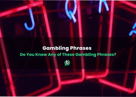 Neon signs of playing cards with glowing red and blue lights, featuring the text “Gambling Phrases – Do You Know Any of These Gambling Phrases?”